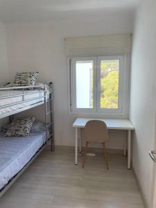 een slaapkamer met een bureau, een bed en een raam bij NUEVO. Reformado con vistas panorámicas y piscina in Pals
