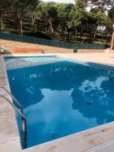 a swimming pool with blue water in a yard at NUEVO. Reformado con vistas panorámicas y piscina in Pals