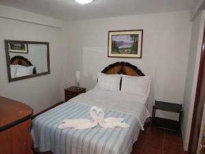 a bedroom with a bed with two towels on it at Hospedaje El Rinconcito in Jauja