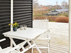 a white picnic table and chairs on a deck at 5 person holiday home in B rkop in Egeskov