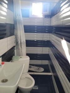 ein Badezimmer mit einem weißen WC und einem Waschbecken in der Unterkunft Narcis House in Thessaloniki