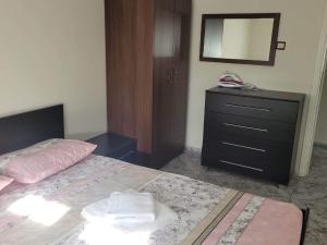 1 dormitorio con 1 cama y vestidor con espejo en Narcis House, en Tesalónica