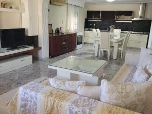a living room with a couch and a table and a kitchen at Narcis House in Thessaloniki
