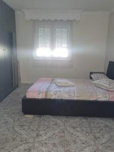 sypialnia z łóżkiem przed oknem w obiekcie Narcis House w Salonikach