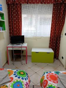 Schlafzimmer mit einem Schreibtisch, einem Computer und einem Fenster in der Unterkunft Domus Cornelia in Neapel