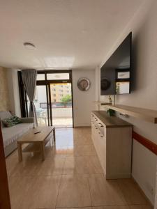 una cucina e un soggiorno con divano e tavolo di Apartment Modern 2 Playa del Ingles a San Bartolomé