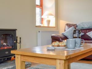 a coffee table in a living room with a fireplace at Old Mill Cottage in Blair Atholl