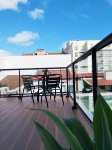 a balcony with a table and chairs on top of a building at Santa Alegria Hostel in Ponta Delgada