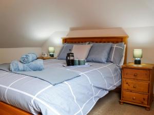 a bedroom with a large bed with blue pillows at Old Mill Cottage in Blair Atholl