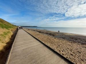 una passerella sulla spiaggia con persone che ci camminano sopra di Summer Breeze - Cosy & Warm Holiday Home in Youghal's heart - Family Friendly - Long Term Price Cuts a Youghal