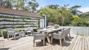 a wooden table and chairs on a wooden deck at Hillview Cottage in Bowral