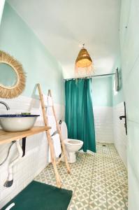 La salle de bains est pourvue d'un rideau de douche vert et de toilettes. dans l'établissement Appartement a ksar SGHIR en face du terminal passagers de Ferry port Tanger Med, à Ksar Sghir