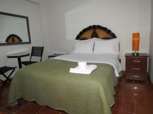 um quarto com uma cama grande e uma vela. em Hospedaje El Rinconcito em Jauja