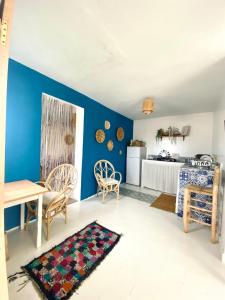 a living room with blue walls and a table and chairs at Appartement a ksar SGHIR en face du terminal passagers de Ferry port Tanger Med in Ksar es Sghir