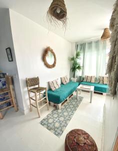 a living room with a green couch and a table at Appartement a ksar SGHIR en face du terminal passagers de Ferry port Tanger Med in Ksar es Sghir