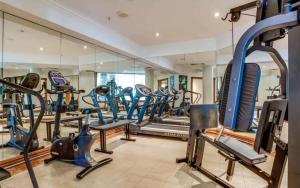 een fitnessruimte met rijen loopbanden en machines bij The Moroccan - QStay in Gold Coast