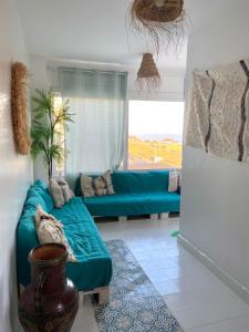 - un salon avec un canapé vert et une fenêtre dans l'établissement Appartement a ksar SGHIR en face du terminal passagers de Ferry port Tanger Med, à Ksar Sghir