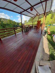 a wooden deck with a table and chairs on it at EcoGranjasYa in El Peñol