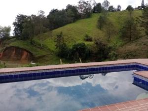 a pool with a reflection of the sky in the water at EcoGranjasYa in El Peñol