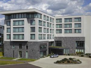 a building with a car parked in front of it at Hotel Fire & Ice Düsseldorf/Neuss in Neuss