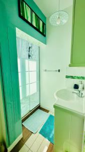 ein Bad mit einem Waschbecken und einer Glasdusche in der Unterkunft Appartement Bleu du Palais - Relaxation Centrale in Le Palais