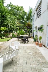um pátio com bancos e mesas num quintal em Gran Jaguar Hotel em Bacalar