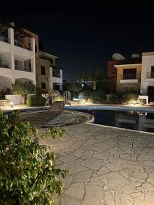 Paphos的住宿－Apartament Cosy House with pool, Paphos Pafos,Tombs of Kings，享有泳池和建筑物的夜间景致