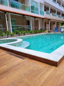 a swimming pool in front of a building at Pousada Concha Dourada in Maragogi