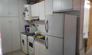 a kitchen with white cabinets and a white refrigerator at Departamento Citrino in Godoy Cruz +18 photos