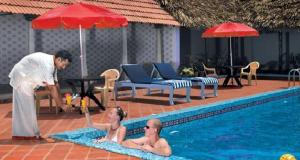 two men are standing in a swimming pool at Chettinadu Mansion – An Authentic Heritage Palace in Kānādukāttān