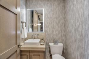 a bathroom with a sink and a toilet and a mirror at Premium One Bedroom apartment hotel in Park City