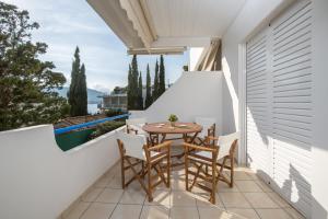 un patio con tavolo e sedie sul balcone. di Del Mar Luxury Apartment 30m From The Beach a Porto Rafti