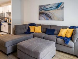 a living room with a gray couch with yellow pillows at Ideal Modern Retreat in Jacksonville