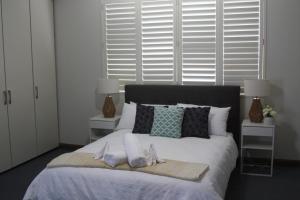 a bedroom with a bed with two towels on it at Bennett's Bliss - Ocean View, 5 Bedrooms, 14 Guest in Forster