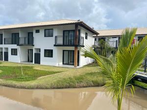 ein Haus mit einem Fluss davor in der Unterkunft Apartamento Praia do Forte in Mata de Sao Joao