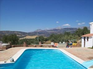 una piscina azul con vistas a las montañas en Casa dos ponies, en Ríogordo