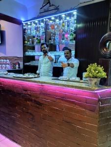 dos hombres parados detrás de la barra en un restaurante en Sea View Hotel, en Hurghada