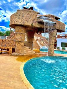 una piscina con una fuente de agua en un complejo en Haras Paraíso do Atlântico 