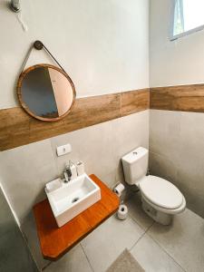 ein Badezimmer mit einem WC, einem Waschbecken und einem Spiegel in der Unterkunft Surfway Ilha do Mel Lofts in Ilha do Mel