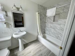 a white bathroom with a sink and a shower at Desert Inn in Mojave