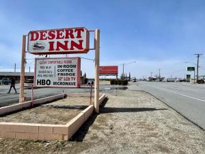 ein Schild für ein Wüstengasthaus am Straßenrand in der Unterkunft Desert Inn in Mojave