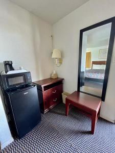 um quarto de hotel com um espelho, uma mesa e uma cadeira em Desert Inn em Mojave