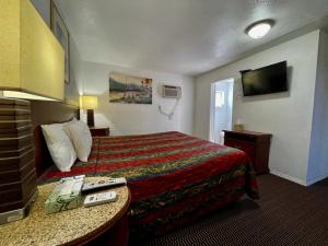 a hotel room with a bed and a television at Desert Inn in Mojave