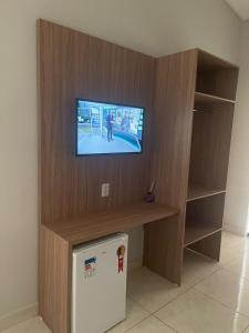 a room with a tv on a wall with a washing machine at Haras Paraíso do Atlântico 