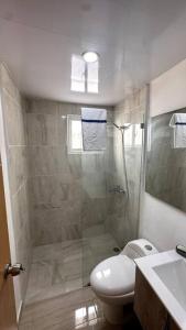 een badkamer met een douche, een toilet en een wastafel bij Brand New Apt in PUNTA CANA. in Punta Cana