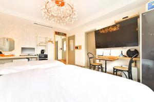 1 dormitorio con 1 cama blanca grande y escritorio en Hotel February Tongyeong Jukrim, en Tongyeong