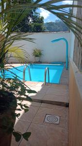 a swimming pool in a backyard with a blue pool at Pousada Santo Expedito in Tiradentes