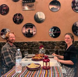 a man and woman sitting at a table in a restaurant at Riad Chay & Boutique in Ouarzazate