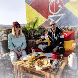 a man and a woman sitting at a table with food at Riad Chay & Boutique in Ouarzazate