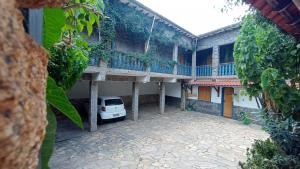 a building with a car parked in the courtyard at Pousada Santo Expedito in Tiradentes